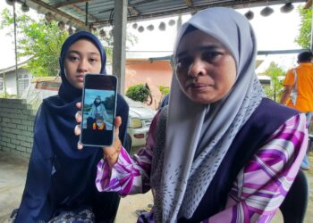 MAZLINA DIN (kanan) bersama anak bongsunya, Zaireel Arysha Saiful Nizam
menunjukkan gambar arwah Nurul Fateha Amyra Saiful Nizam di rumah mereka di Kampung Keda Sungai Salleh, Serdang, Bandar Baharu hari ini. - UTUSAN/AZAHAR HASHIM