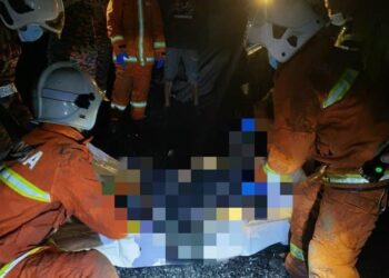 ANGGOTA Bomba mengeluarkan mangsa rentung dalam kebakaran di Kampung Tikolod, Tambunan hari ini.-IHSAN BOMBA