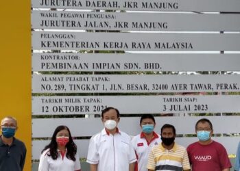 NGEH Koo Ham (tiga dari kiri) di hadapan papan tanda projek jejantas pejalan kaki di Kampung Ayer Tawar dekat Beruas hari ini.