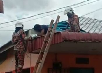 TANGKAP layar daripada video menunjukkan anggota bomba memeriksa mayat seorang lelaki yang maut akibat renjatan elektrik di sebuah rumah di Lorong Pauh, Derga, Alor Setar hari ini. - MEDIA SOSIAL