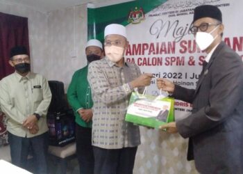 IDRIS Ahmad (tengah) menyerahkan sumbangan pada majlis penyampaian sumbangan kepada calon peperiksaan SPM dan STAM di Taiping hari ini. - UTUSAN/WAT KAMAL ABAS