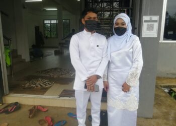 SITI Rau’ah Fatihah bersama Muhammad Firdaus Zamri ke pusat pemindahan sementara (PPS) Kampung Lubuk Periuk selepas selamat bernikah di Masjid Felda Mengkawang, Hulu Terengganu, hari ini. - UTUSAN/NOOR HAYATI MAMAT