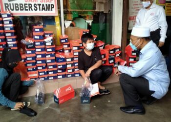 IDRIS Ahmad berbual dengan pelajar yang menerima bantuan persekolahan pelajar asnaf di Taiping hari ini. - UTUSAN/WAT KAMAL ABAS