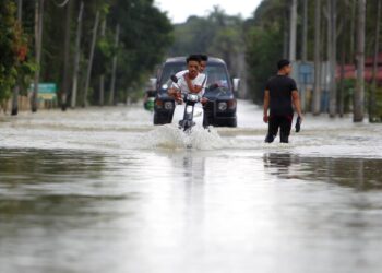 KEADAAN Jalan Meranti ke Rantau Panjang dinaiki air banjir di Kampung Bakong, Pasir Mas. - UTUSAN/ZULHANIFA SIDEK