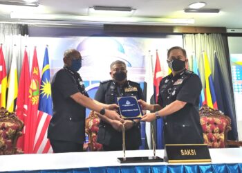 IDRIS Abdullah (tengah) menyaksikan pertukaran jawatan antara Abdul Rahman Kassim (kiri) kepada Ang Seow Aun (kanan) di IPK Sabah di Kota Kinabalu hari ini.