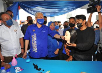 ISMAIL Sabri Yaakob beramah mesra dengan salah seorang pelatih dandanan sambil diperhatikan Hasni Mohammad dan Noraini Ahmad sempena Majlis Pelancaran Kolej Komuniti Satelit@Pontian di Kompleks Muafakat Sungai Pinggan, Benut, Pontian. - UTUSAN/RAJA JAAFAR ALI