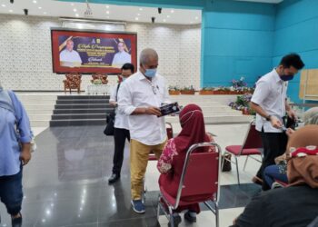 NAZRI Ngah (tengah) menyampaikan biasiswa Yayasan Pahang kepada seorang penjaga di Dewan Pejabat Majlis Daerah Jerantut di Jerantut, Pahang. - UTUSAN/SALEHUDIN MAT RASAD