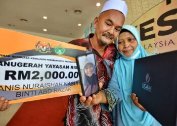 ABD. Razak Isa dan Najah Aspalela Alias menunjukkan diploma yang diterima arwah anak mereka, Nur Hanis Nuraishah selepas Majlis Konvokesyen UCAM kali ke-19 yang diadakan di Dewan Tuanku Canselor USIM, Nilai, Seremban, hari ini. - UTUSAN/MOHD. SHAHJEHAN MAAMIN
