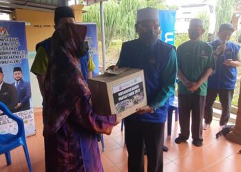 IDRIS Ahmad menyampaikan bantuan banjir kepada 200 penduduk di Kampung Seberang Tayur di Kemaman hari ini. - UTUSAN/NIK NUR IZZATUL HAZWANI NIK ADNAN