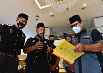AHMAD Hairi Hussain (kanan) melihat memorandum yang diserahkan Syed  Nasarudin Syed Abdul Hadi (tengah) berkaitan rentetan isu perlembagaan syariah yang perlu diperkasakan di Kuantan, Pahang. - -UTUSAN/SHAIKH AHMAD RAZIF