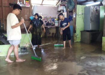 NOR Shafida Othman (tengah) bersama dua anaknya membersihkan rumah selepas dimasuki air dan lumpur dalam kejadian banjir kilat di Kampung Bendang Sera, Baling. - UTUSAN/NORLIA RAMLI