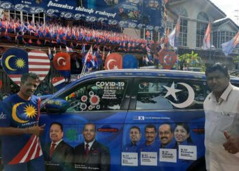 M. Kandapan (kiri) menunjukkan kereta Proton X70 miliknya dengan hiasan pemimpin dan calon BN daripada MIC di Bandar Seri Alam, Pasir Gudang di Johor.