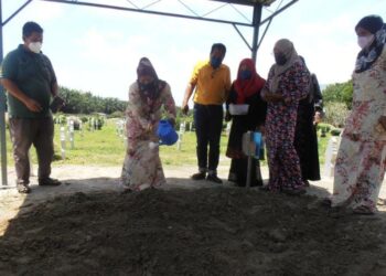 NORBAIZURA Abu Bakar menyiram air mawar dikubur Misha Kasih selepas selesai pengebumian di Tanah Perkuburan Islam Raudatul Mawaddah, Sungai Batu, Merbok, Sungai Petani hari ini. - UTUSAN/OTHMAN YAHAYA
