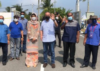 HISHAMMUDDIN Hussein bersama R. Vidyananthan (dua kanan) selepas selesai mengundi di Sekolah Agama Taman Sri Lambak, Kluang.