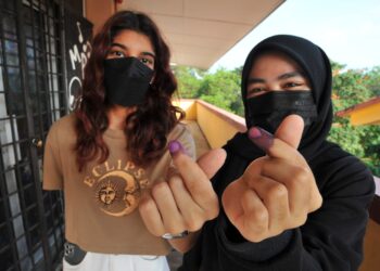 DUA pengundi baharu, Nadia Nur Aisyah Abdull Manan (kanan) dan Sanjena Ananthan menunjukan jari mereka yang diwarnakan setelah mengundi buat pertama kali pada PRN Johor di SK Taman Sutera, Johor Bahru. - UTUSAN/RAJA JAAFAR ALI