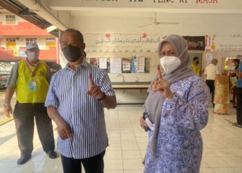 MUHYIDDIN Yassin dan isteri, Puan Sri Norainee Abd. Rahman selesai mengundi di SMK Sri Muar, Johor. - UTUSAN/NUR ALINA HASSAN