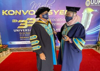ISMAIL  Zakaria memperkatakan sesuatu kepada Izati Khairul Nisa selepas menerima ijazah masing-masing pada Majlis Konvokesyen Ke-33 UUM di Dewan Muadzam Shah UUM, Sintok, Kedah hari ini. - UTUSAN/JAMLIAH ABDULLAH