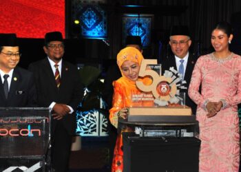 RAJA Zarith Sofiah Sultan Idris Shah berkenan meletakkan logo 50 tahun UTM sempena pelancaran sambutan berkenaan sambil diperhatikan Che Puan Besar Khaleeda Bustamam dan Ahmad Fauzi Ismail (kiri) di Dewan Sultan Iskandar, UTM Skudai. - UTUSAN/RAJA JAAFAR ALI