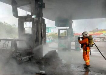 ANGGOTA dari BBP Rantau Panjang berusaha memadamkan kebakaran sebuah kereta di stesen minyak di Rantau Panjang, Kelantan hari ini. - UTUSAN/YATIMIN ABDULLAH