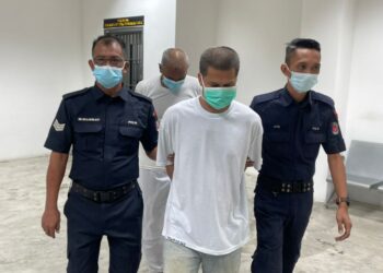 MOHD. Rozani Yahaya (tengah) dibawa ke Mahkamah Tinggi Kota Bharu hari ini untuk mendengar keputusan pertuduhan bagi kes bunuh yang dihadapinya. - UTUSAN/MUHAMMAD AYMAN GHAFFA