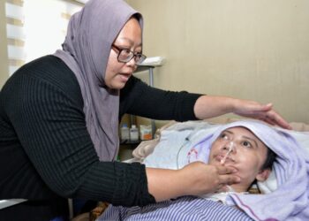 FAUZIAH Nordin menunjukkan keadaan Jahidah yang semakin kurus dengan luka bedsore di bahagian belakang badan dan kakinya yang semakin teruk ketika ditemui di Bandar Sri Sendayan, Seremban hari ini. - UTUSAN/MOHD. SHAHJEHAN MAAMIN