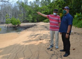 ROSLI Osman (kanan) dan Ahmad Ismail ketika melihat kesan sisa tumpahan minyak di persisiran pantai dekat Tanjung Tuan, Port Dickson, semalam. - FOTO/ZAKKINA WATI AHMAD TARMIZI