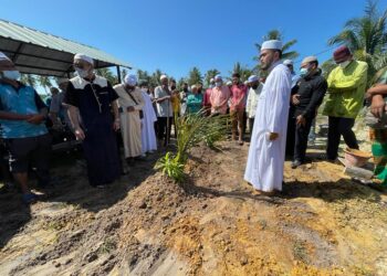 NIK Muhammad Zawawi bersama penduduk menyempurnakan pengebumian arwah isterinya, Wan Sofiza Eliana Wan Yusof di Pantai Melawi, Bachok hari ini. - UTUSAN/TOREK SULONG