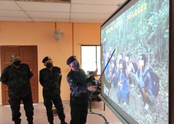 MAT Shukor Yusof (kanan) menunjukkan gambar-gambar PATI Myanmar yang berjaya ditahan pihaknya kepada pemberita di Markas Taktikal Lubok Stol, Rantau Panjang, Kelantan hari ini. - UTUSAN/YATIMIN ABDULLAH