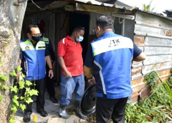 MUHAMMAD Fauzi Abd Ghani (kiri) memeriksa rumah penginapan pekerja dalam operasi di Kampung Kepayang dekat Simpang Pulai hari ini. - UTUSAN/ZULFACHRI ZULKIFLI
