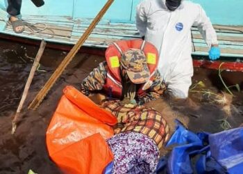 ANGGOTA bomba mengangkat mayat wanita yang mati dibaham buaya di Sungai Telong Suai, Batu Niah, Miri.