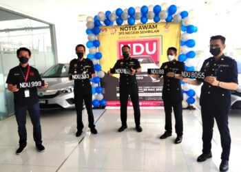 HANIF Yusabra Yusuf (tengah) menunjukkan nombor pendaftaran siri 'NDU' yang dijangka mendapat hasil kutipan sebanyak RM1.3 juta. - UTUSAN/NOR SHAFAWATI YUP