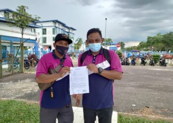 JAMALUDDIN  Abdul Malik (kanan) menunjukkan laporan polis dibuat pihaknya terhadap ‘Kak Long 7e’ yang mempersenda golongan OKU di media sosial di IPD Seri Alam, Pasir Gudang, Johor.