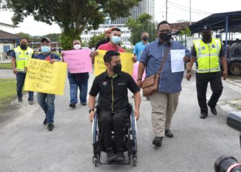 AHLI Persatuan Sahabat OKU Perak keluar dari Balai Polis Sungai Senam, Ipoh hari  selepas membuat laporan polis terhadap seorang individu yang menghina golongan OKU. - UTUSAN/ZULFACHRI ZULKIFLI