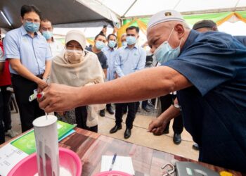 ZURAIDA Kamaruddin (dua dari kiri) melihat susu getah yang akan diproses menjadi lateks dalam Majlis Pelancaran Insentif Pengeluaran Latex di MHJ Enterprise, Kampung Renab, Tanah Merah. - UTUSAN/BAHRUDDIN HATTA