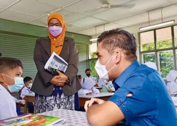 MOHD. Radzi Md. Jidin beramah mesra dengan murid Tahun Satu, Muhamad Zulfan Nazhan Muhamad Zulfikar Affan ketika meninjau SK Syed Idrus, Chemor di Ipoh hari ini. - UTUSAN/MOHAMAD HAFIZI MOHD. SAID