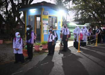 SEBAHAGIAN daripada pelajar SK Bandar Bukit Kayu Hitam, Kubang Pasu beratur untuk memasuki sekolah yang mula dibuka hari ini. - UTUSAN/SHAHIR NOORDIN