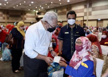 NOH Omar (kanan) menyerahkan sumbangan kepada usahawan selepas merasmikan majlis Penyerahan Sumbangan Banjir Usahawan Keluarga Malaysia di Pusat Konvensyen SACC, Shah Alam, Selangor, hari ini. - UTUSAN / ZULFADHLI ZAKI