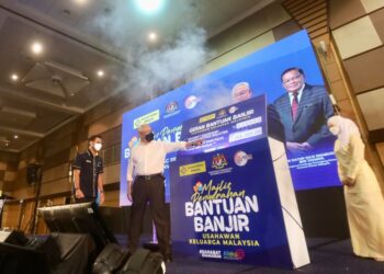 NOH Omar (kanan) bersama Mohamed Shamir Aziz (kiri) merasmikan majlis Penyerahan Sumbangan Banjir Usahawan Keluarga Malaysia di Pusat Konvensyen SACC, Shah Alam, Selangor pada hari ini. - UTUSAN / ZULFADHLI ZAKI