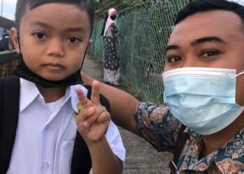 AZIZI Majid bersama anaknya, Aryan Rizqi ketika hari pertama persekolahan di SK Sri Amar, Johor Bahru di sini