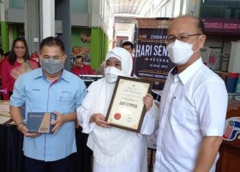 WAN MAIMUNAH Wan Abdul Aziz (tengah) menerima sijil daripada Ngwe Hee Sam sempena Sambutan Hari Seniman peringkat negeri di Kota Fesyen, MITC, Ayer Keroh, Melaka. - UTUSAN/AMRAN MULUP