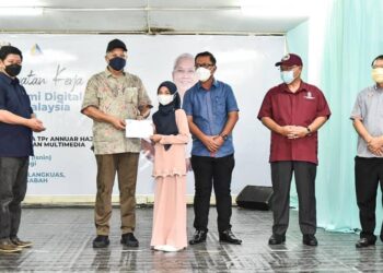 PENYAMPAIAN Pakej Remaja Keluarga Malaysia oleh Annuar Musa (dua kiri) kepada salah seorang penerima di Papar hari ini.