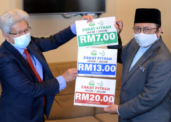 AHMAD Zakiyuddin Abdul Rahman (kiri) bersama Amran Hazali menunjukkan Kadar Zakat Fitrah Negeri Pulau Pinang bagi tahun 2022 di Butterworth, Pulau Pinang hari ini. - UTUSAN/IQBAL HAMDAN