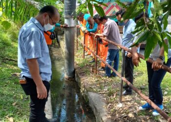 NGWE Hee Sem meninjau longkang yang tersumbat menjadi punca banjir di Taman Pengkalan Indah, Alor Gajah, Melaka. - UTUSAN/AMRAN MULUP