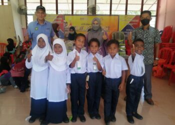 MURID Orang Asli suku Semaq Beri memakai pakaian seragam baharu di Sekolah Kebangsaan Sungai Berua di Hulu Terengganu, semalam. - NOOR HAYATI MAMAT