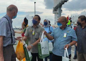 MOHD. Firdaus Ahmad (dua dari kiri) bersama Nasaruddin Abdul Muttalib (dua dari kanan) dan Manoharan Periasamy (kanan) menyerahkan cenderamata kepada pelancong dari Singapura yang tiba di LTAL, Langkawi hari ini. - UTUSAN/NUR AMALINA