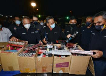 AMINUDDIN Harun (empat dari kanan) bersama Mohamad Mat Yusop (kanan) melihat sejumlah rokok putih dan kretek pelbagai jenama yang dirampas dalam Operasi Bersepadu Agensi Keselamatan Negeri Sembilan yang diadakan di sekitar Port Dickson, semalam. - UTUSAN/MOHD. SHAHJEHAN MAAMIN