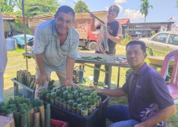 SEREMBAN 2 April -  TALIB Ibrahim (kiri) menunjukkan lemang yang ditempah pelanggan di gerai lemangnya di Taman Desa Kiara, Sikamat, Seremban. - UTUSAN/ NOR SHAFAWATI YUP