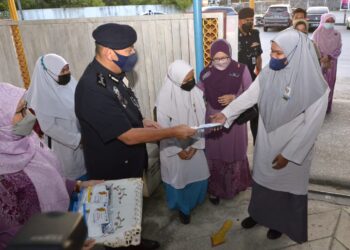 MIOR Faridalathrash Wahid menyampaikan pelitup muka kepada pelajar  pada program Hari Pertama di Sekolah di SMK Raja Perempuan, Ipoh hari ini. - UTUSAN/ZULFACHRI ZULKIFLI