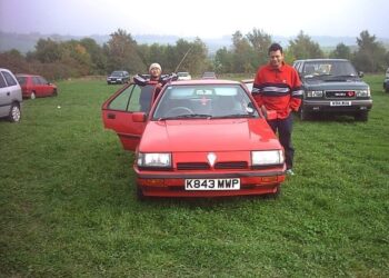 TANGKAP layar memaparkan dua rakyat Malaysia bergambar dengan Proton Saga versi 1988 di Britain. - Foto ihsan Malaysiaku Dulu Dulu Official