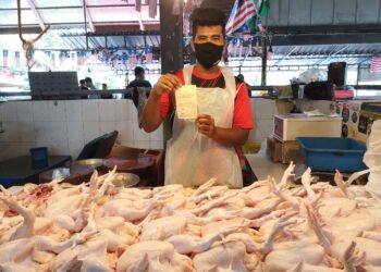 ZURAIDI Zaidi menunjukkan resit kompaun yang dikenakan terhadap majikannya kerana menjual ayam melebihi harga ditetapkan di Pasar Chabang Tiga di Kuala Terengganu, hari ini.